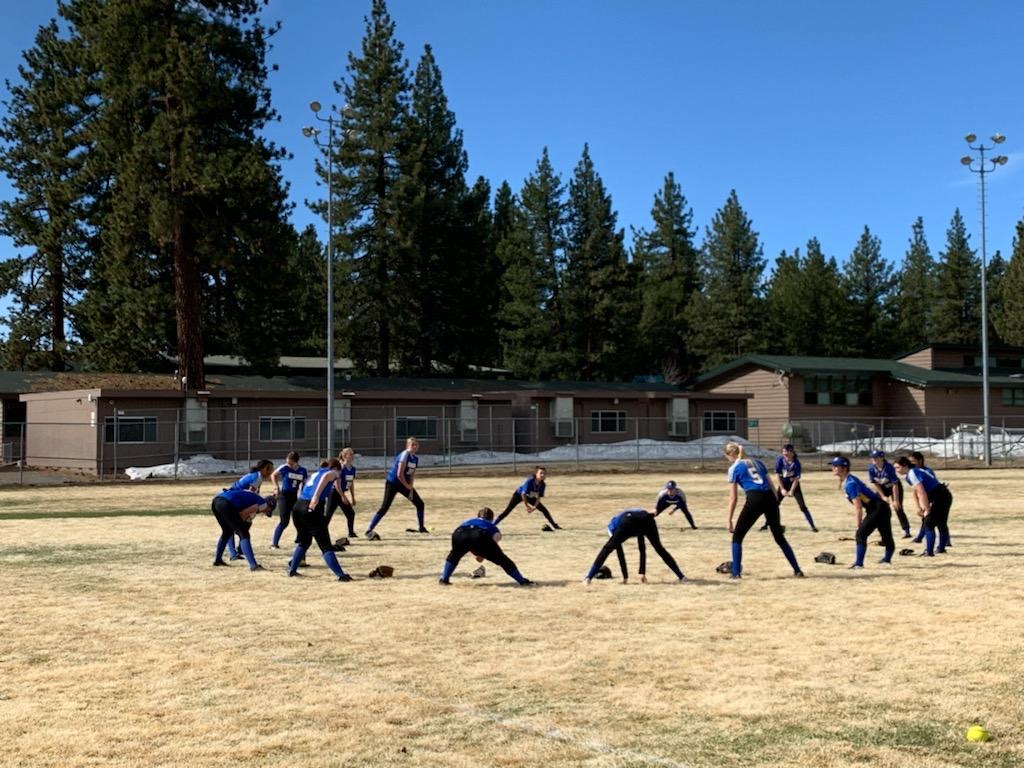 Softball team gathered together outdoors